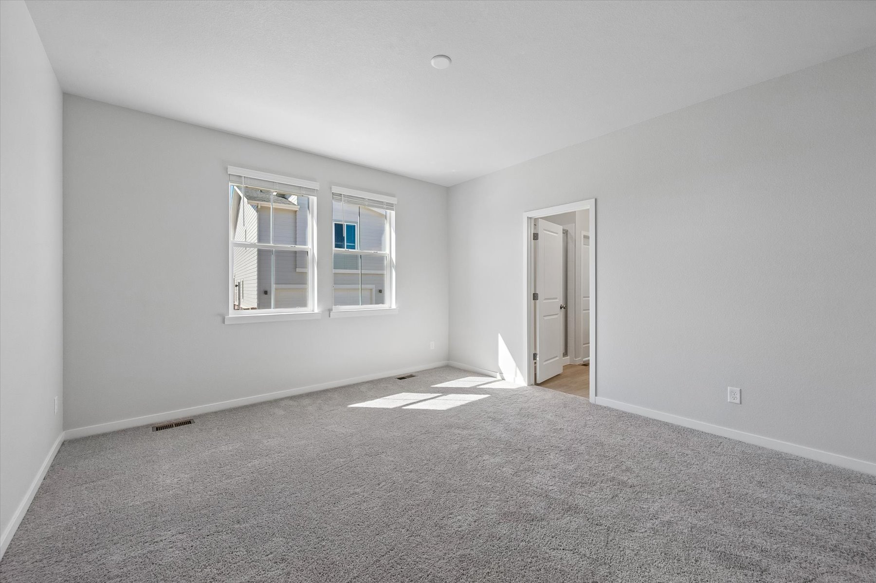 A room with a carpet and windows.