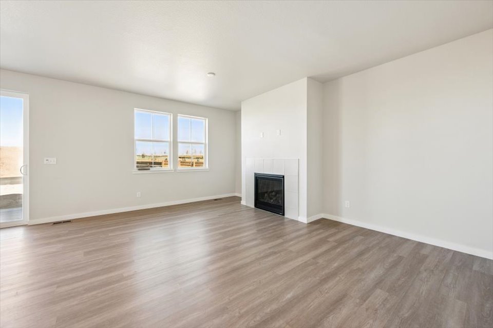 A room with a fireplace and a wood floor.