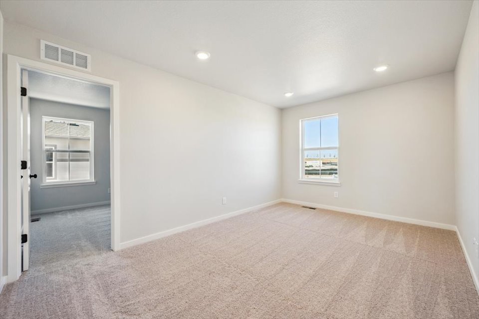A room with a carpet and windows.