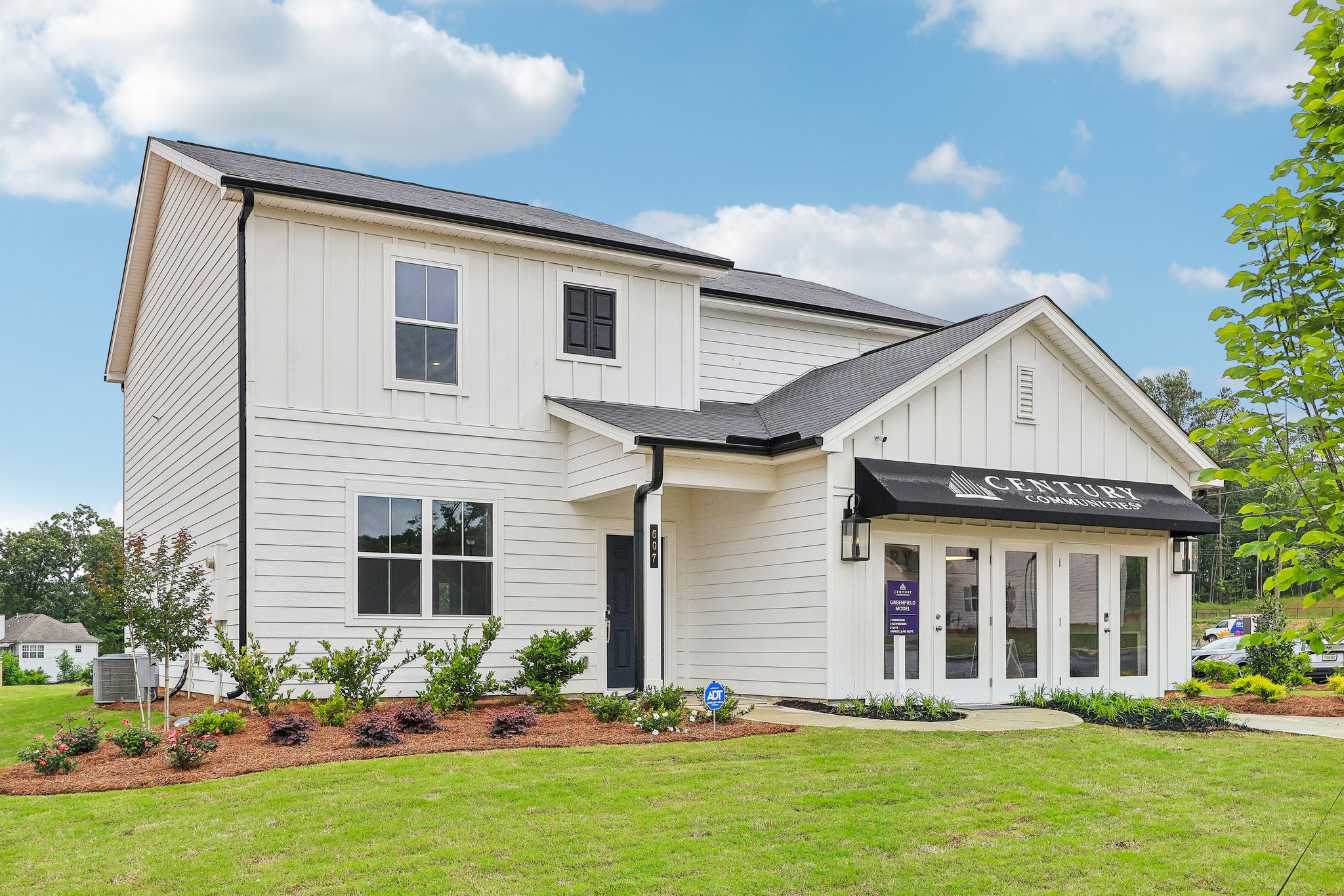 A white house with a lawn in front of it.
