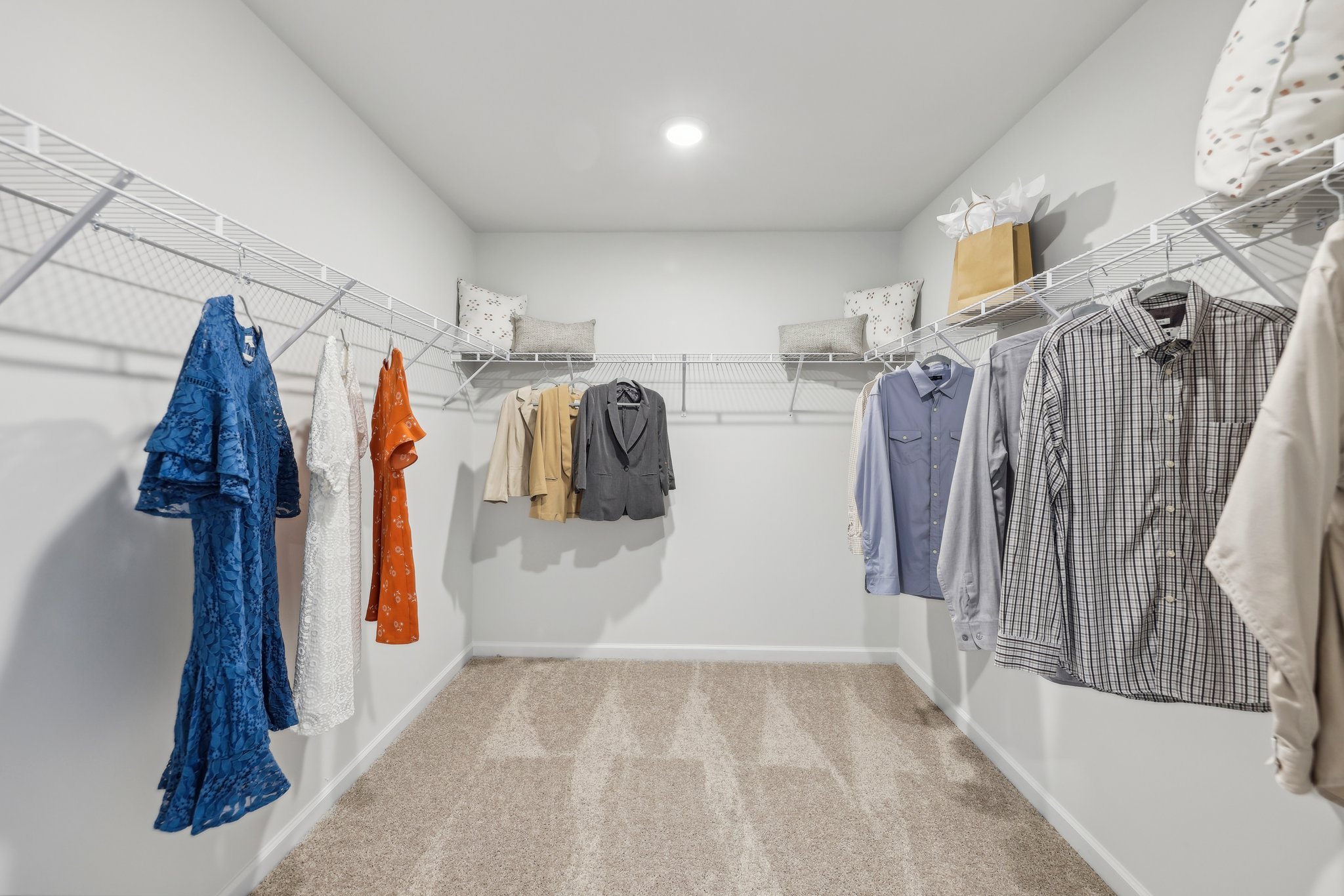 A room with a row of clothes on the wall.