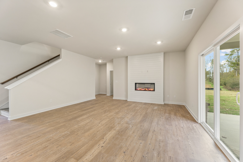 A room with a fireplace and a wood floor.