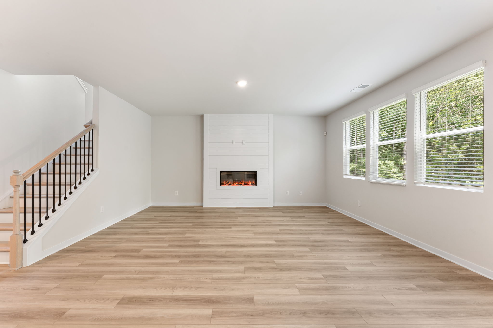 A room with a fireplace and wood floors.