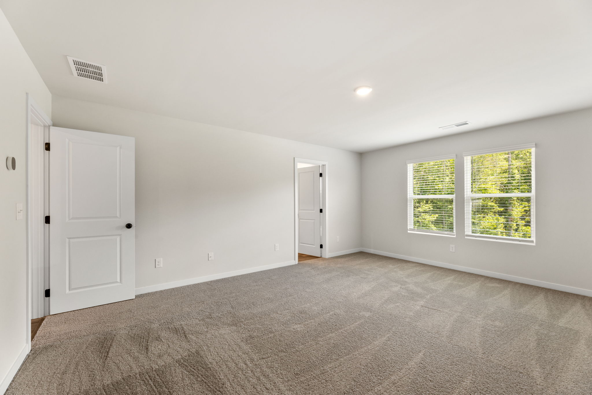 A room with a carpet and a door.