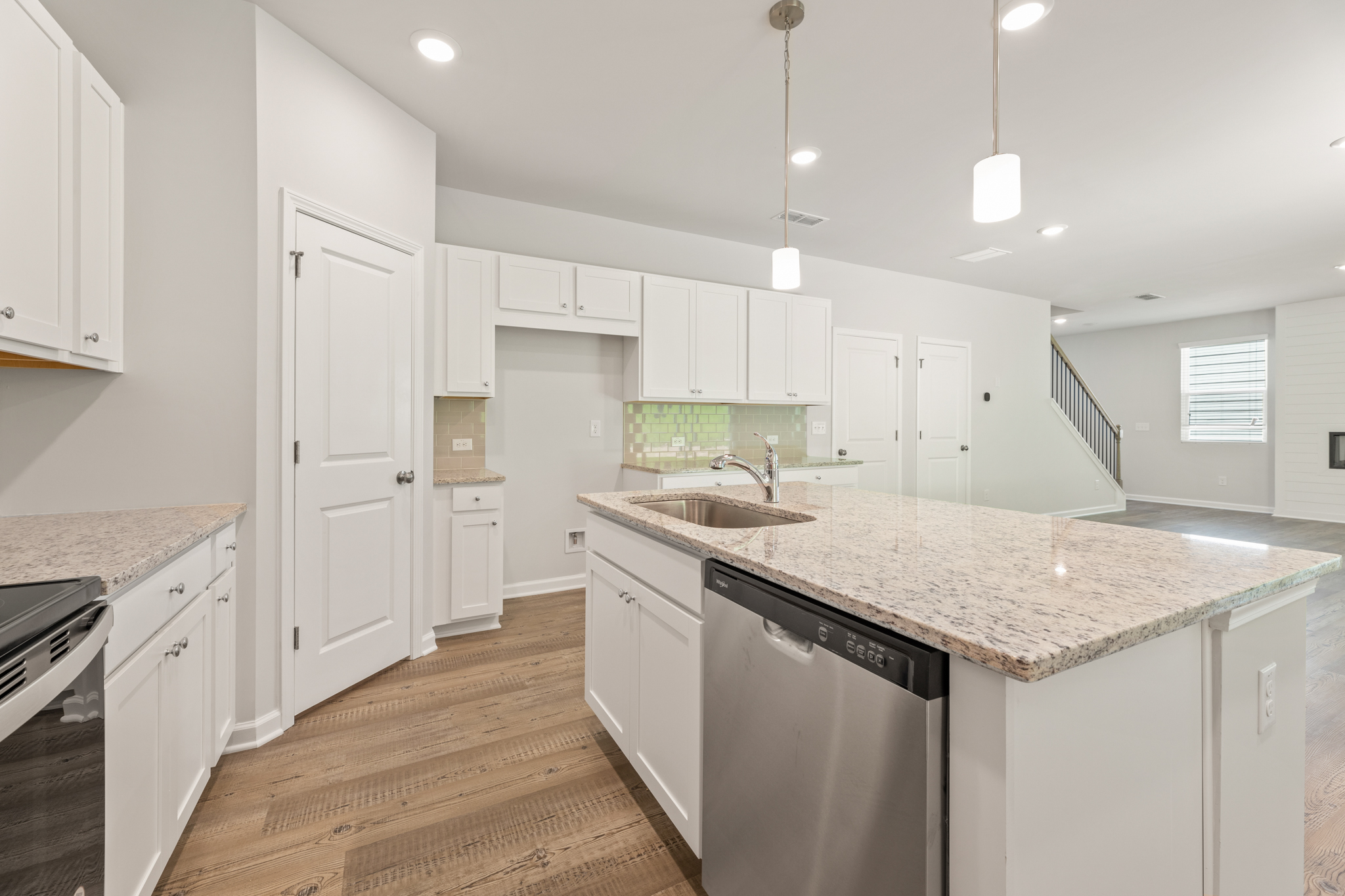 A kitchen with white cabinets.
