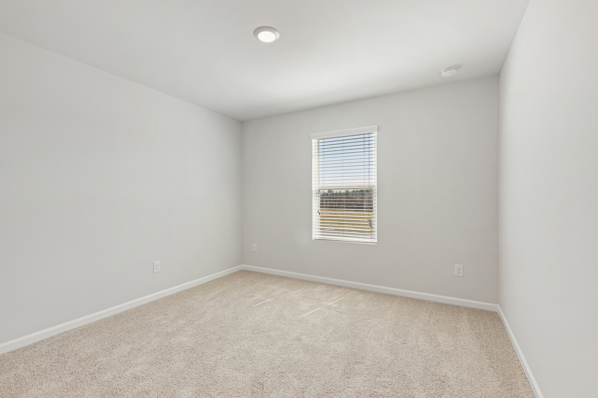 A room with a window and carpet.