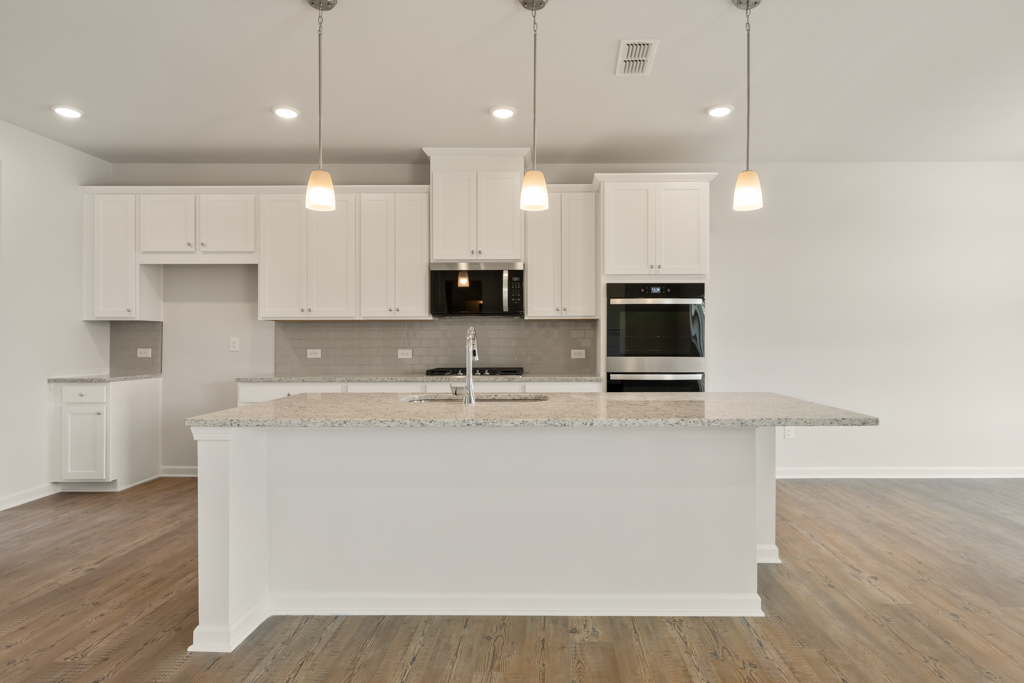 A kitchen with white cabinets.