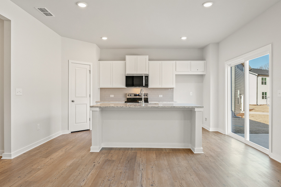 A kitchen with white cabinets.