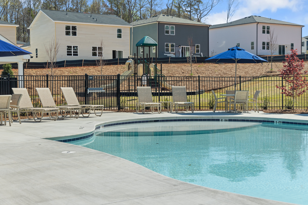 A pool with chairs around it.