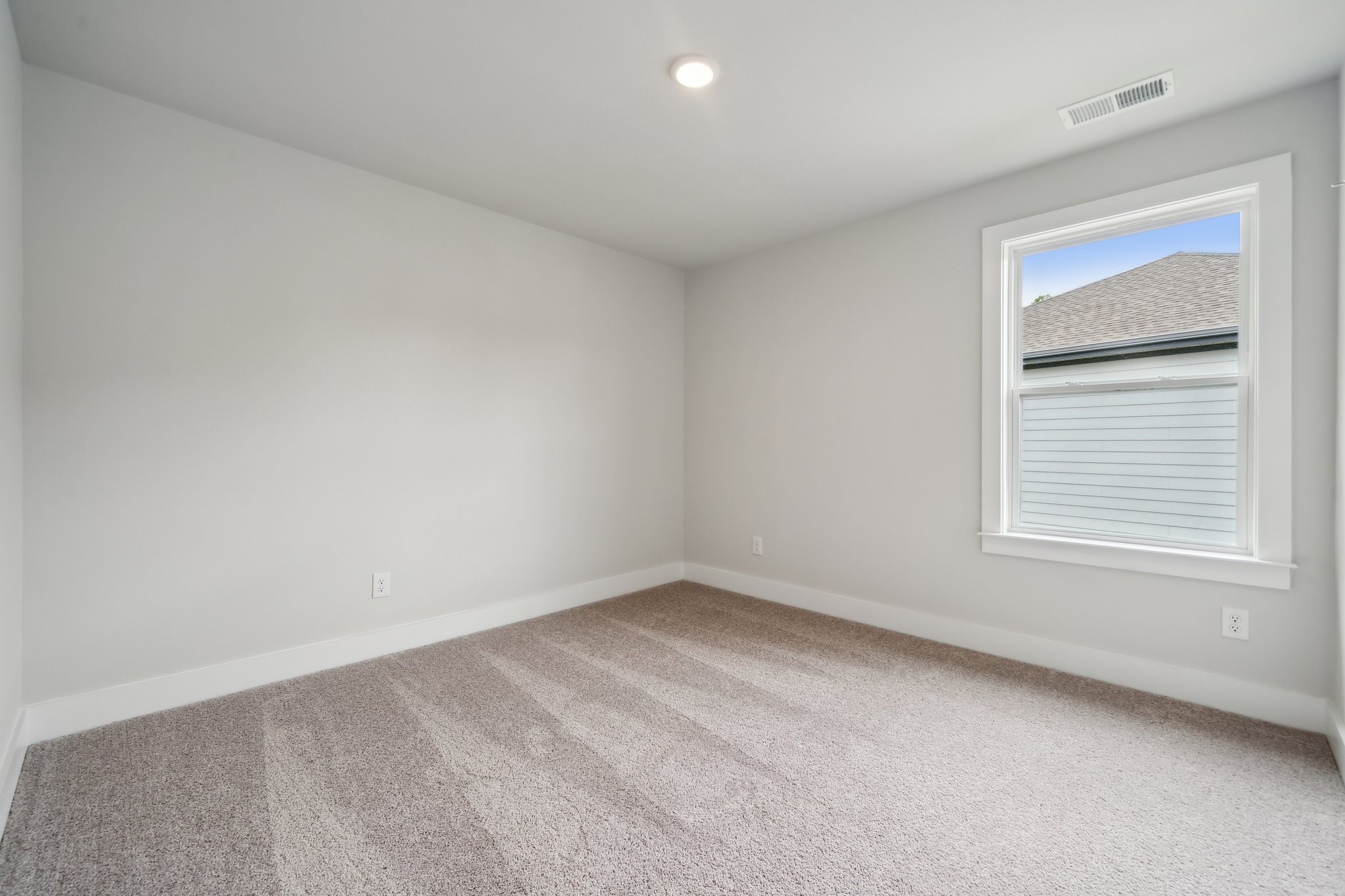 A room with a window and a carpet.