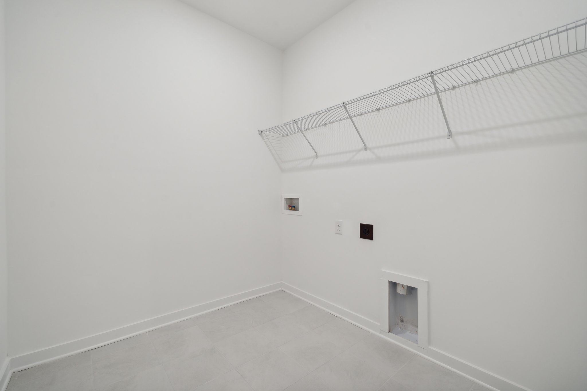 A white hallway with a metal railing.