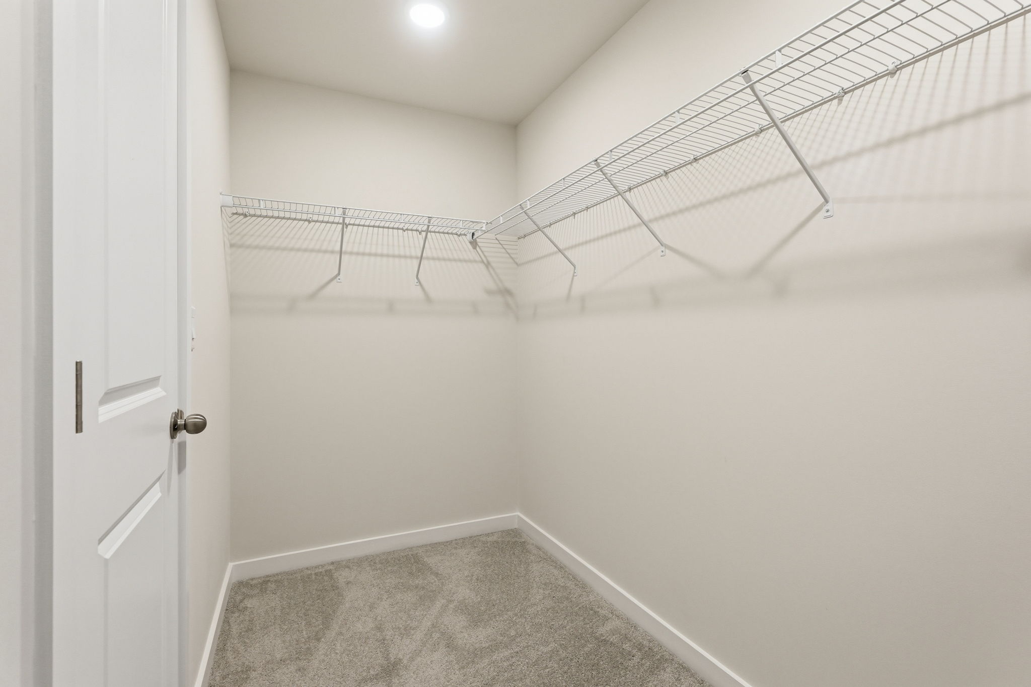 A white tiled room with a metal railing.