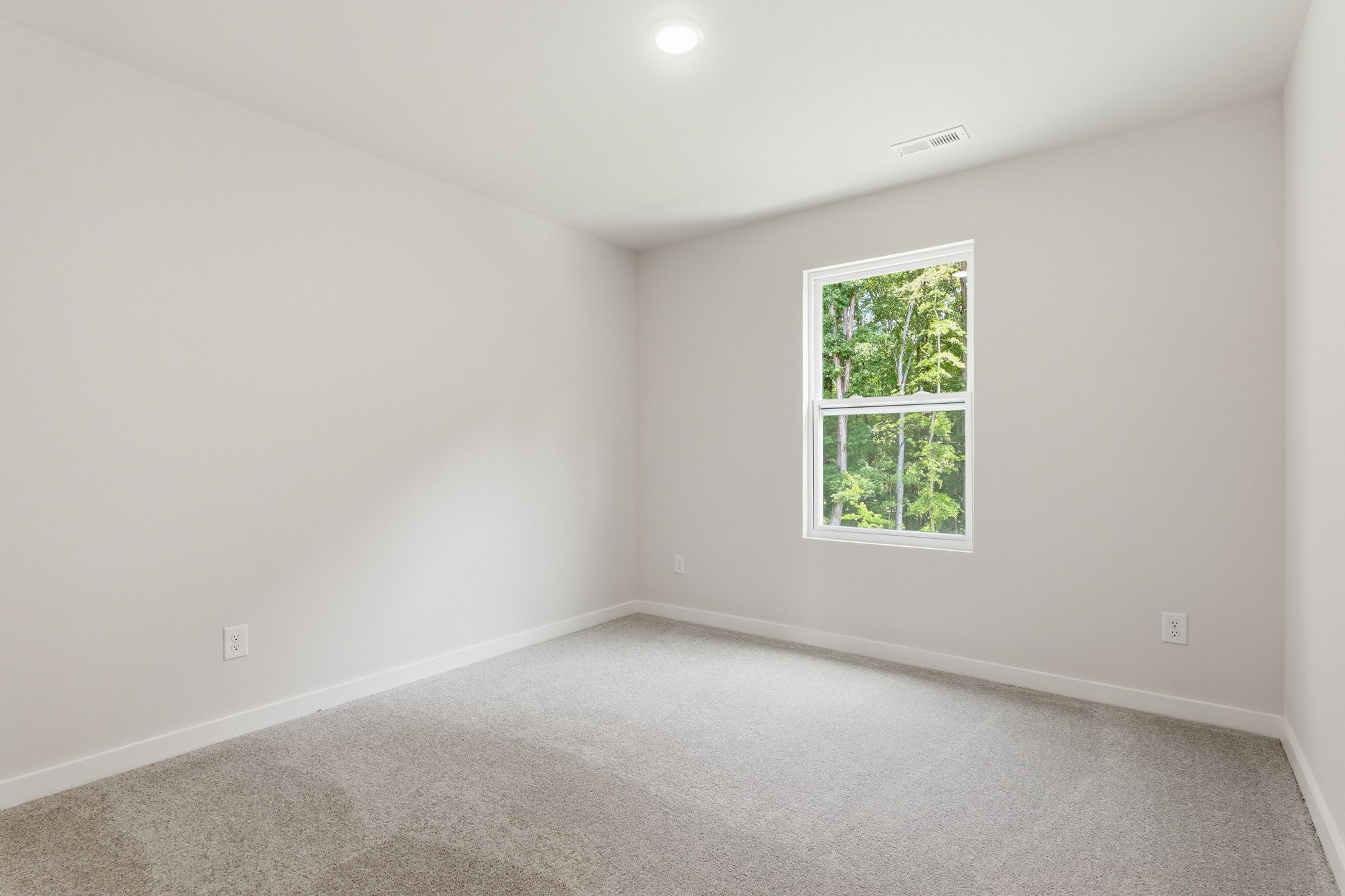 A room with a window and carpet.