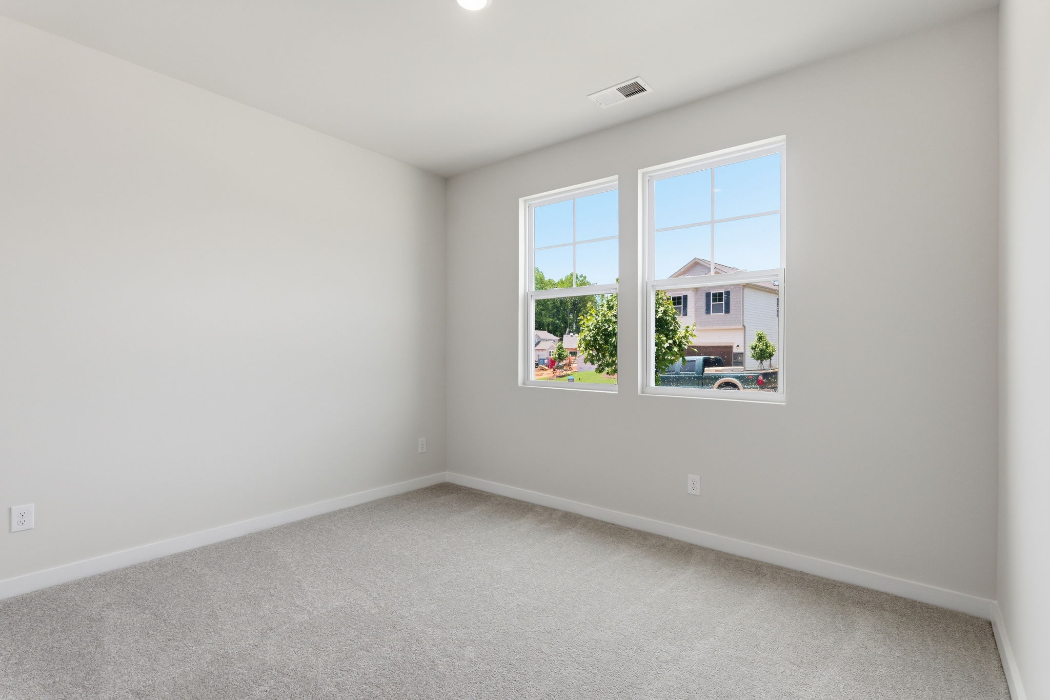 A room with a window and a carpet.