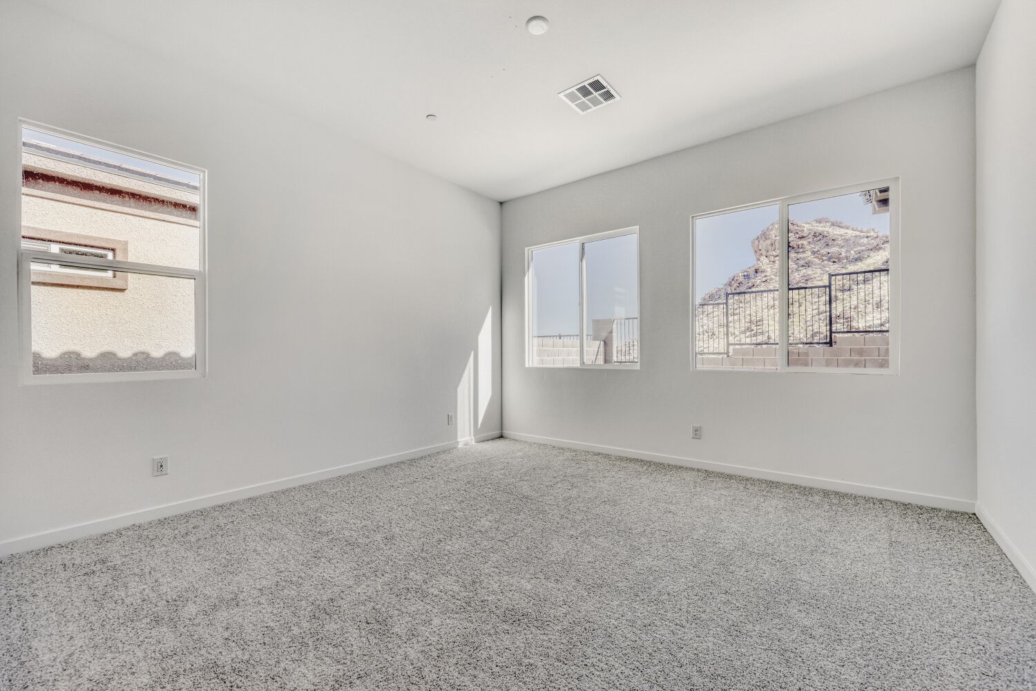 A room with a window and a wall with a painting on it.