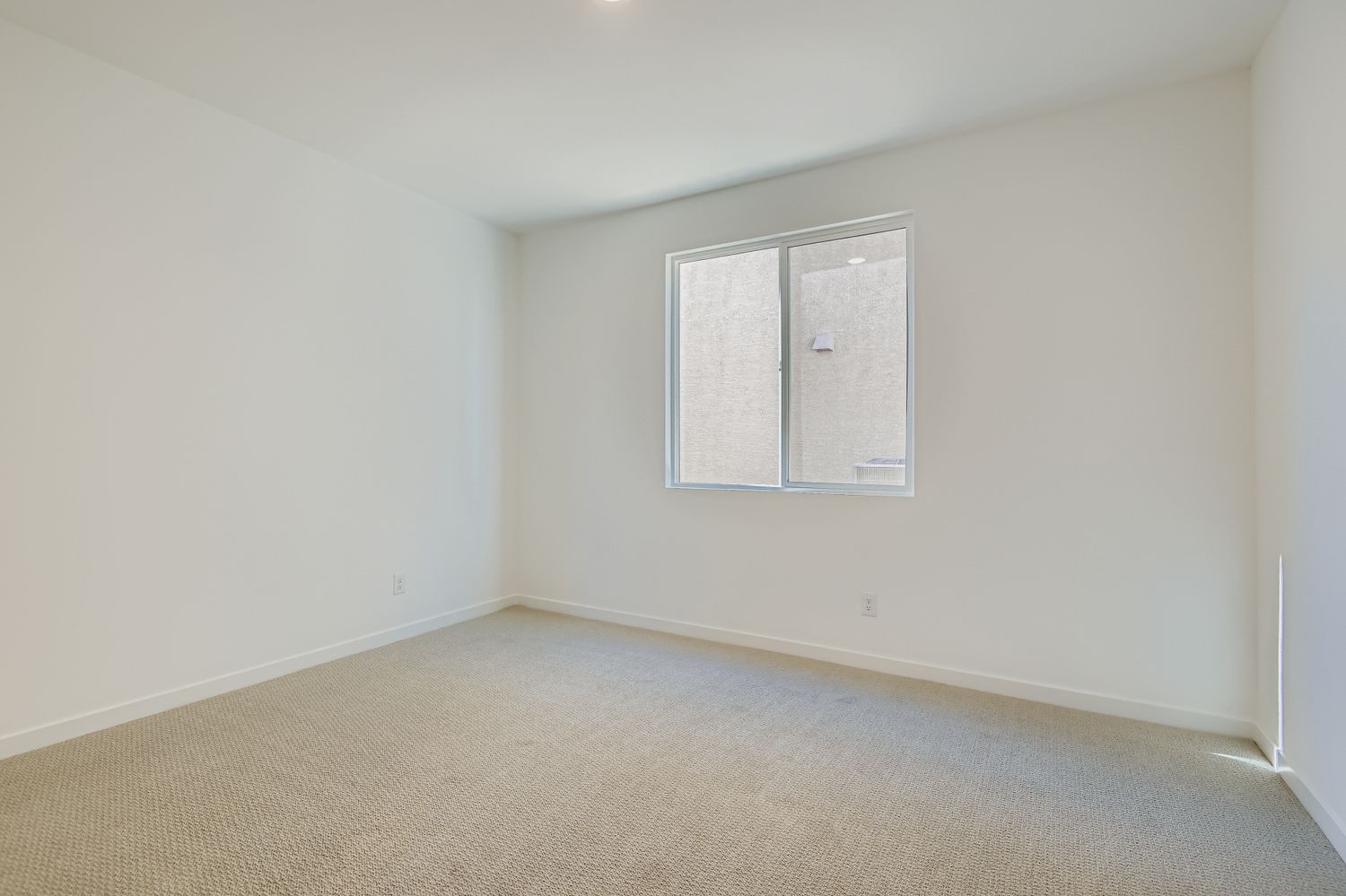 A room with a window and carpet.