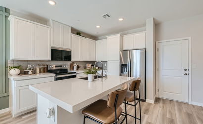 A kitchen with white cabinets.