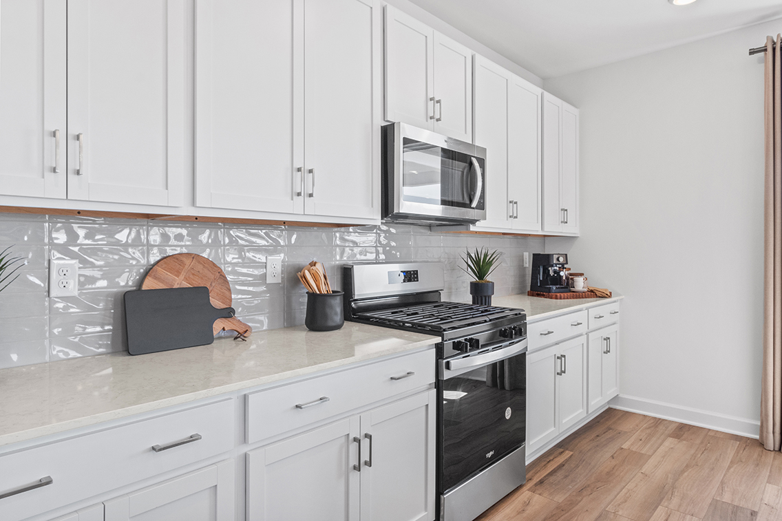 A kitchen with white cabinets.