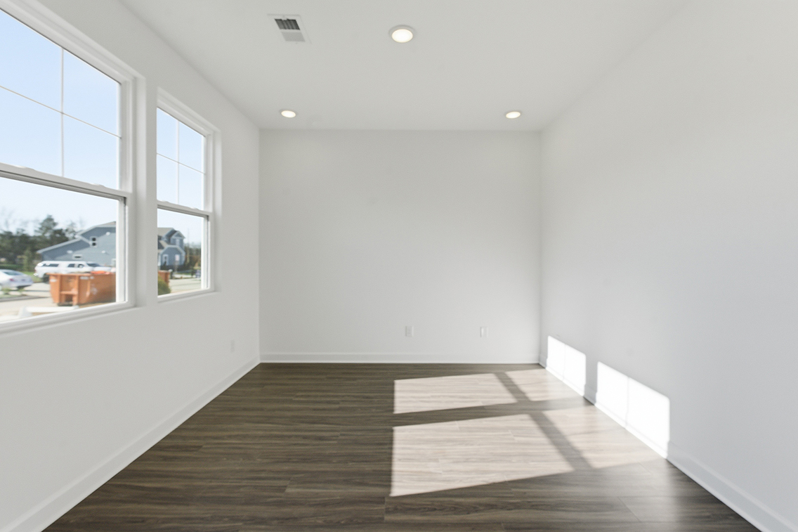 A room with a wood floor and windows.