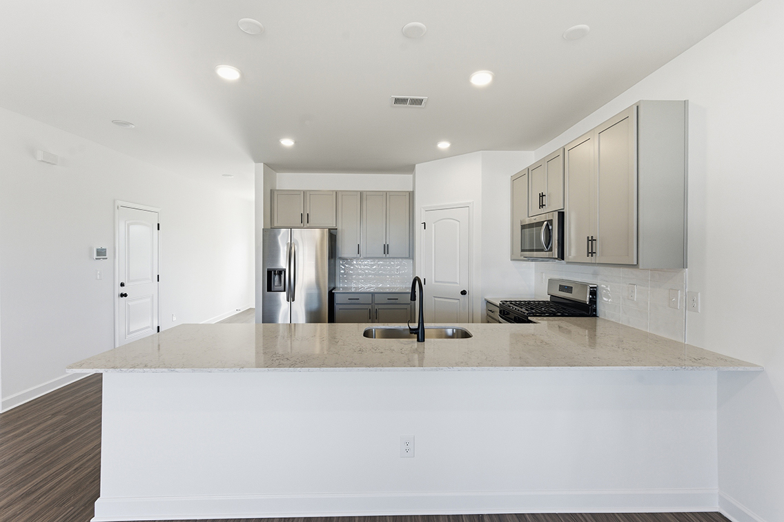 A kitchen with white cabinets.