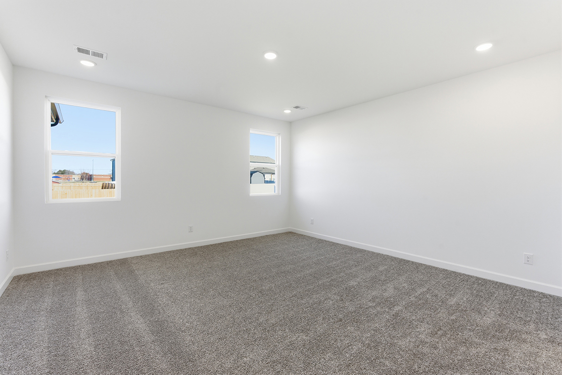 A room with a carpet and a window.