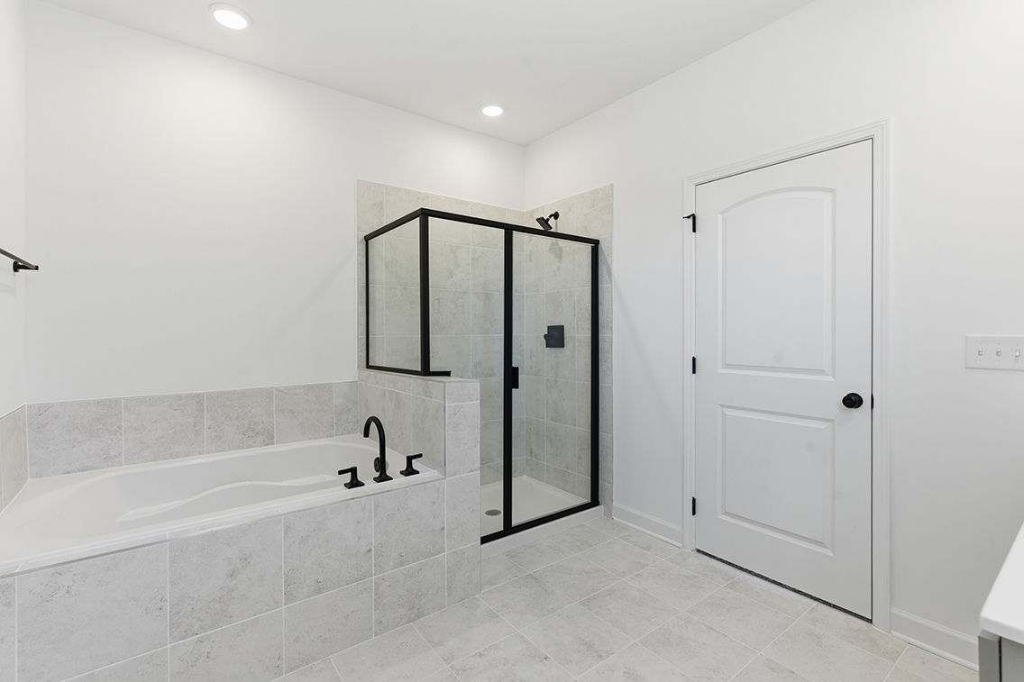 A bathroom with a bathtub and shower.