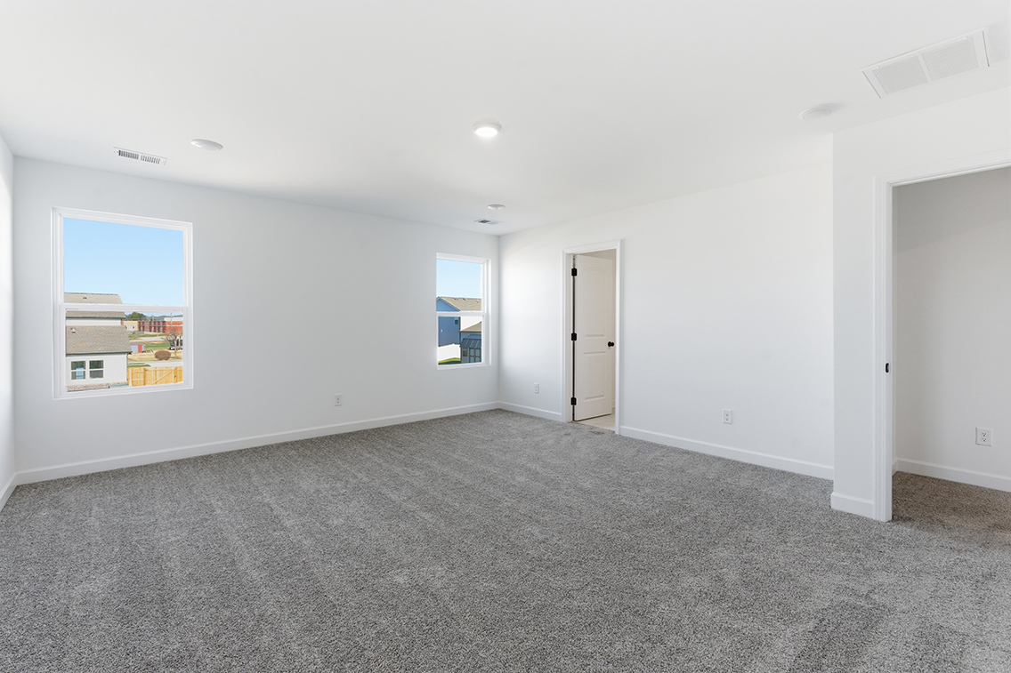 A room with a carpet and a door.