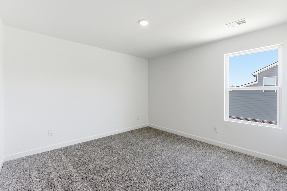 A room with a window and a carpet.