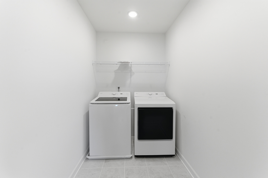 A white room with a white wall and a white stove.