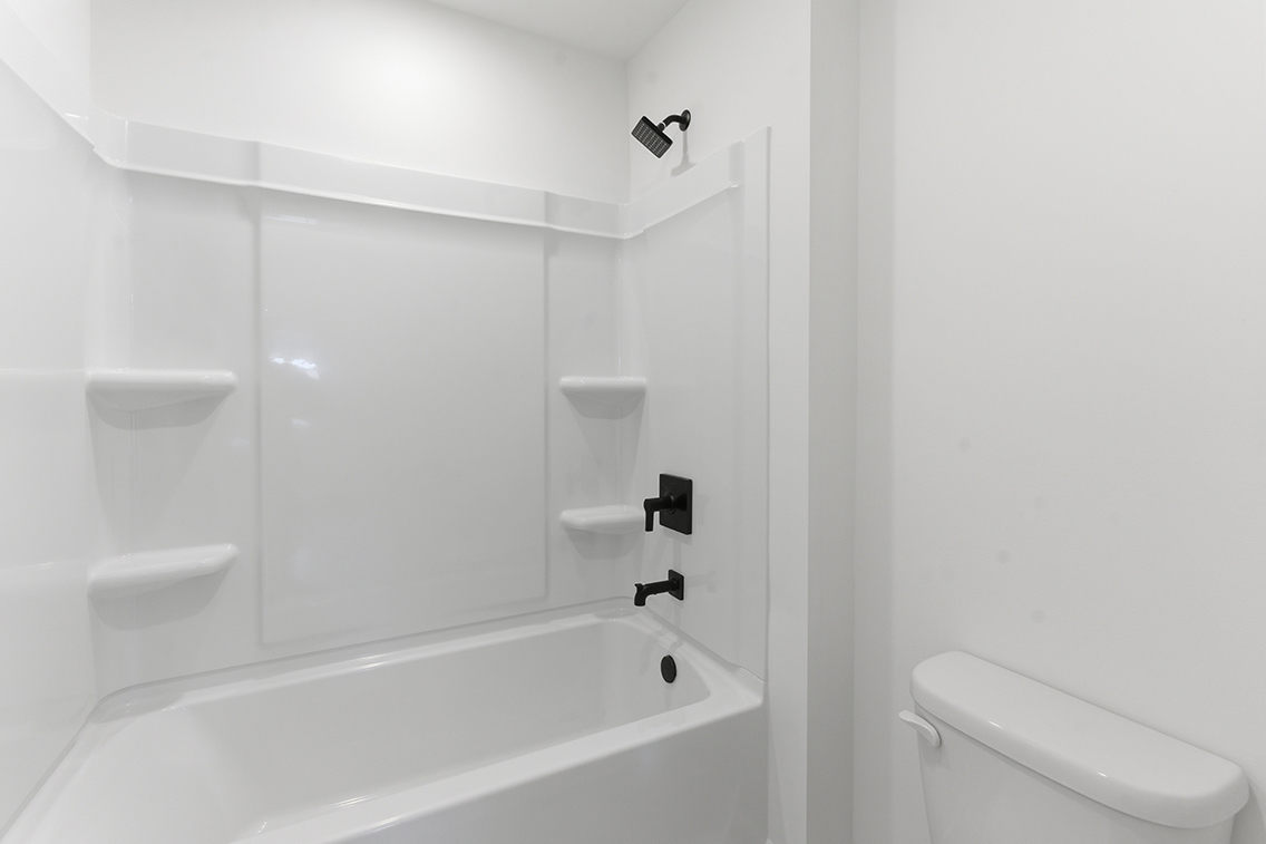 A bathroom with a bathtub and toilet.