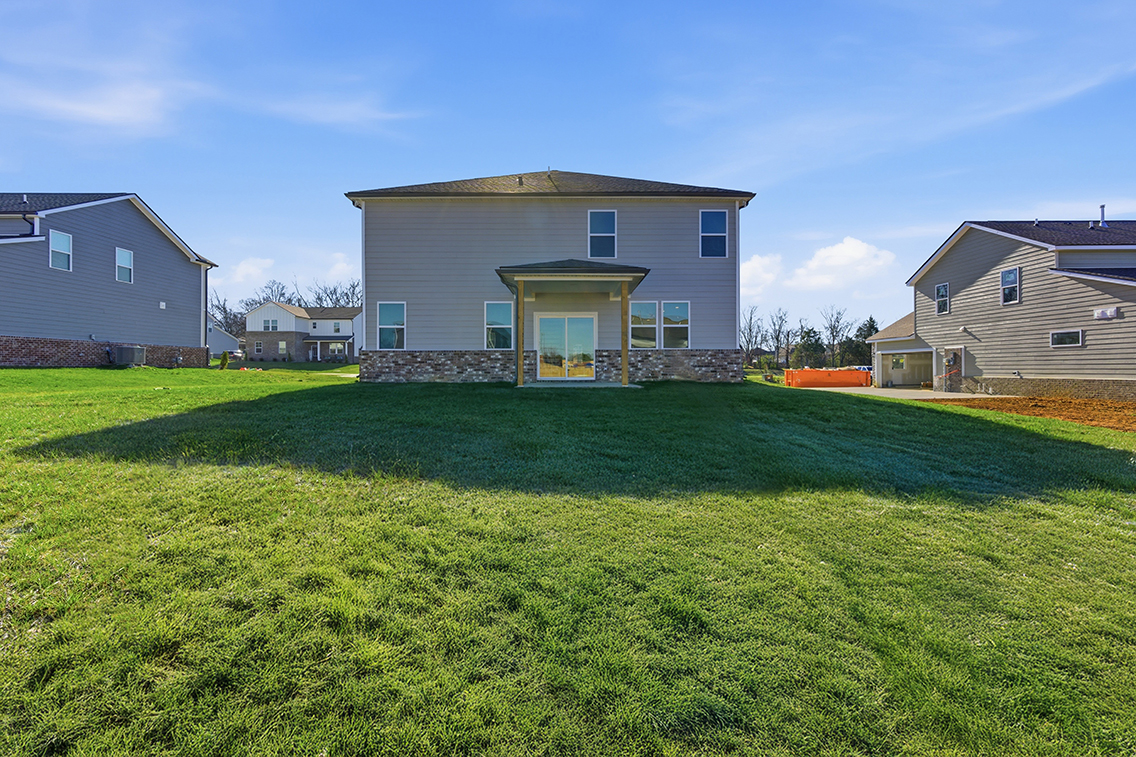 A grassy area with buildings in the background.