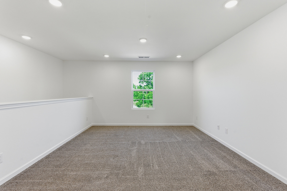 A room with a carpet and a window.