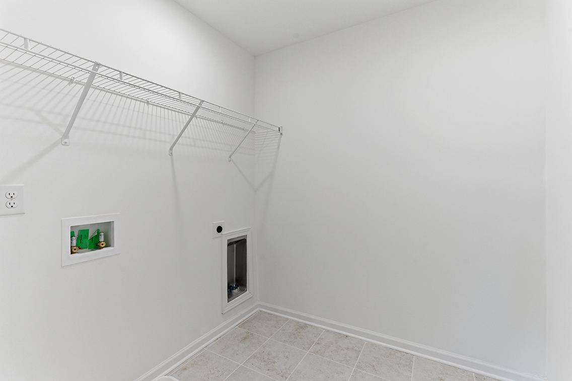A white hallway with pictures on the wall.