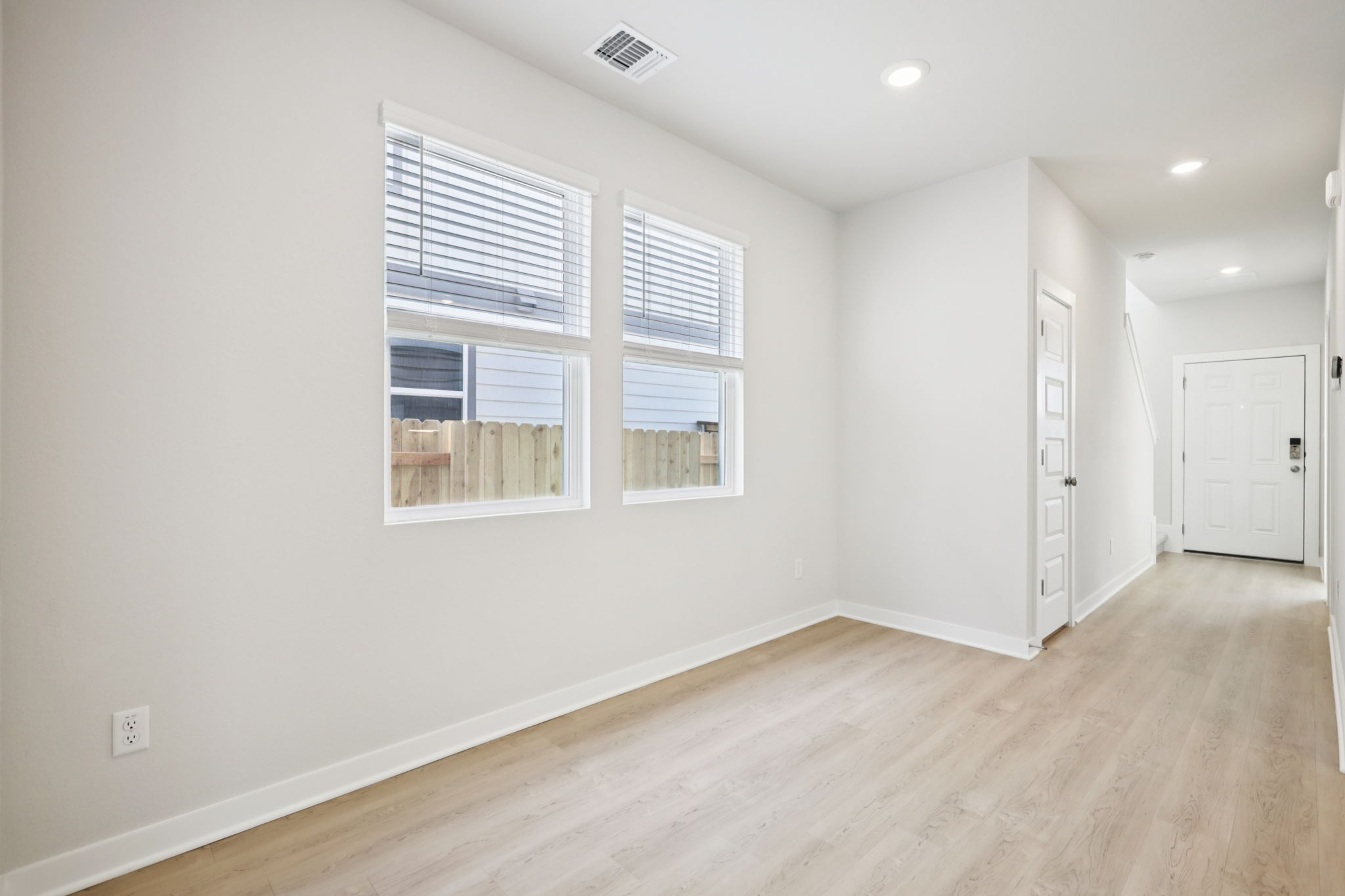 A room with a wood floor and white walls.