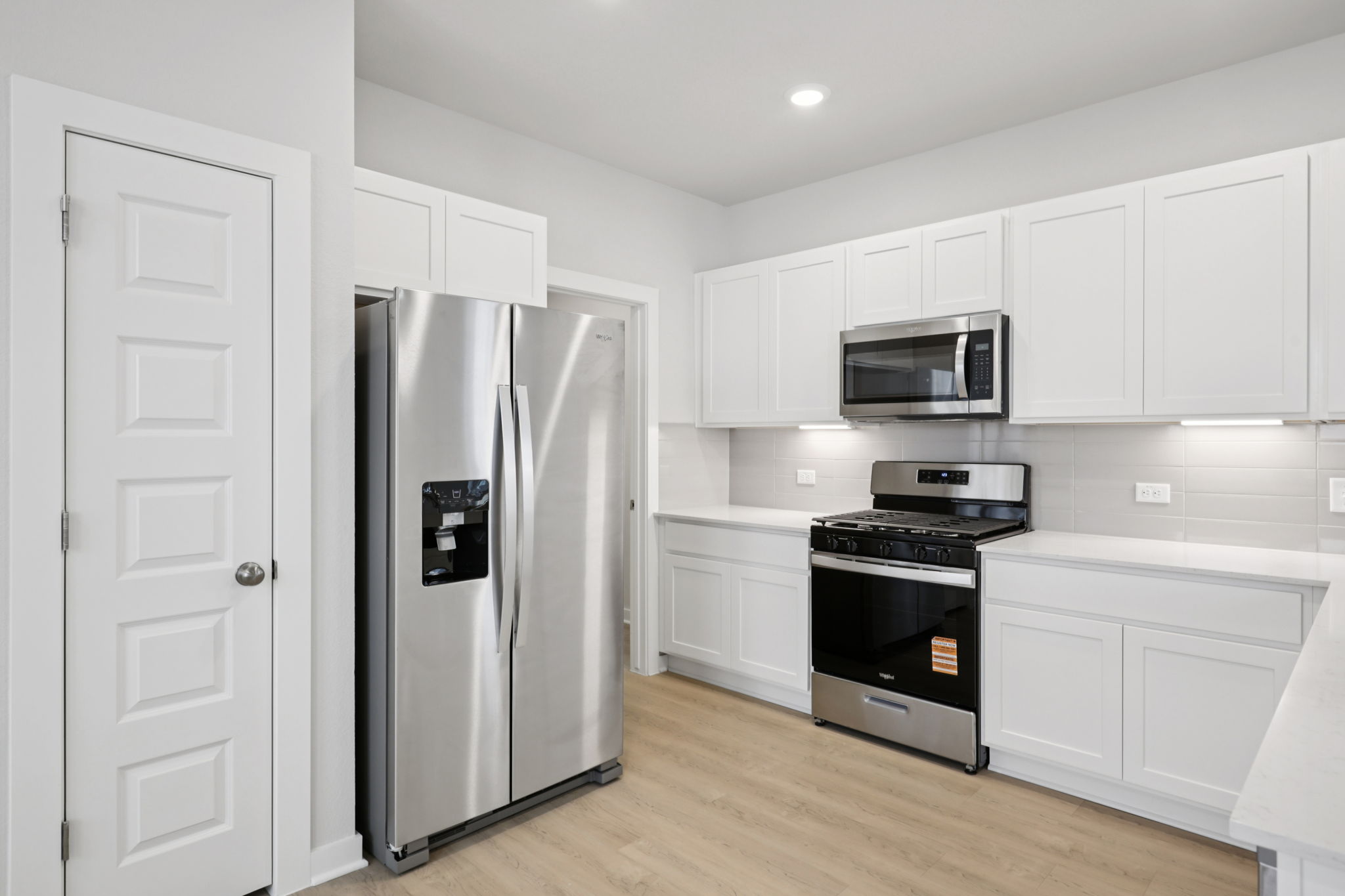 A kitchen with white cabinets.