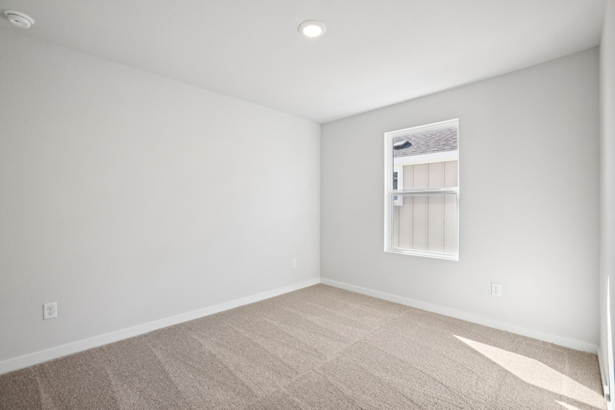 A room with a window and carpet.