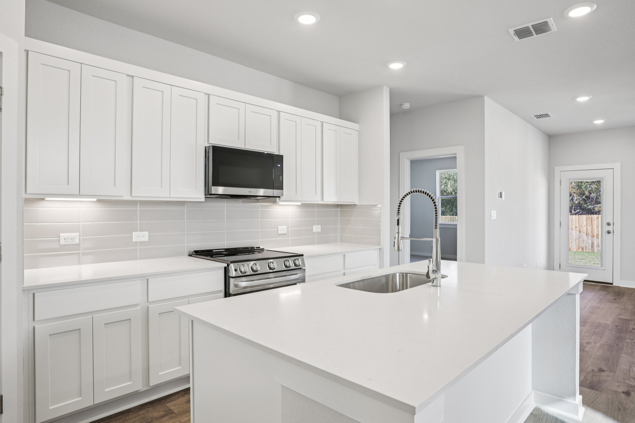 A kitchen with white cabinets.