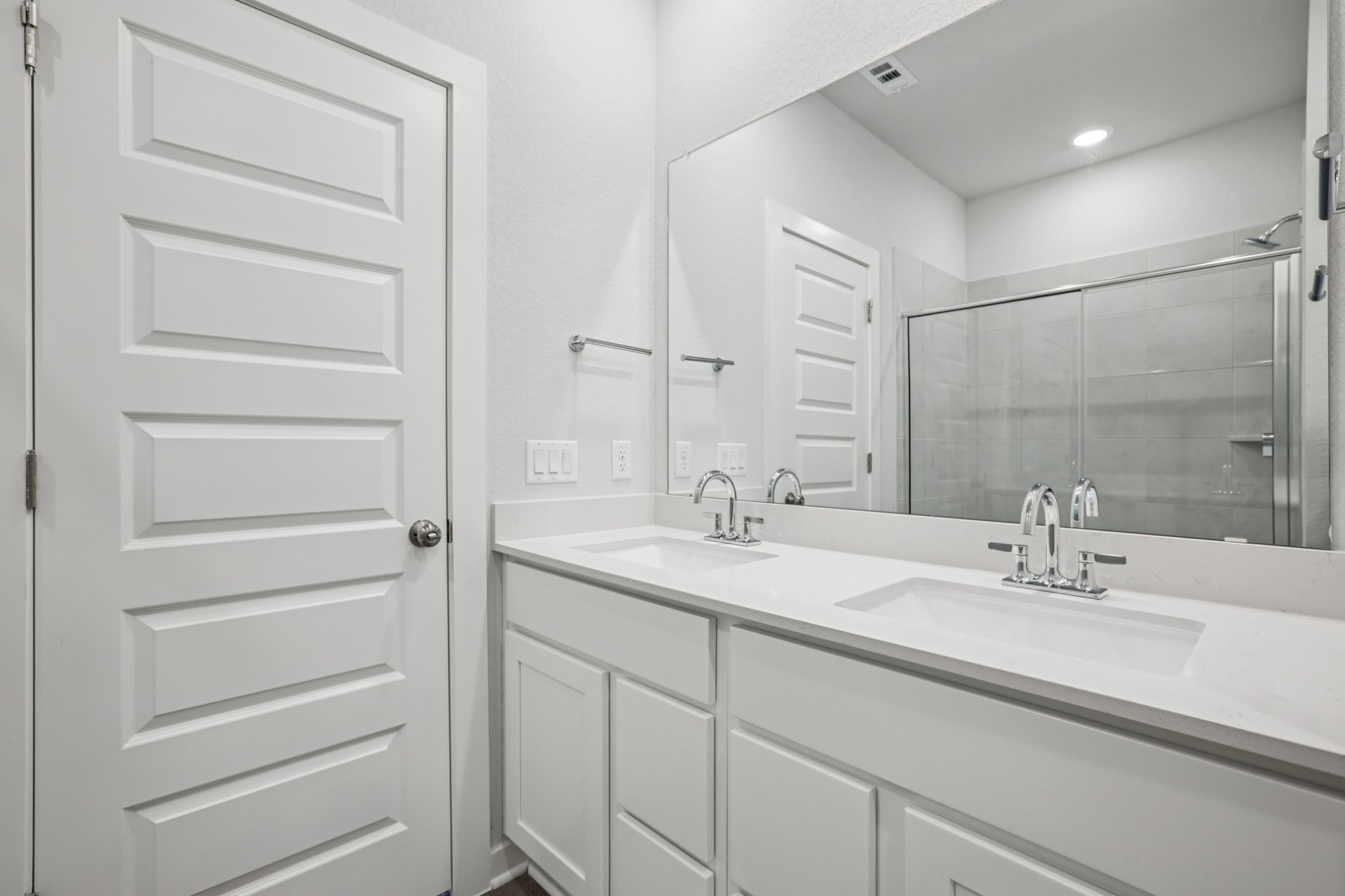 A bathroom with a large mirror.