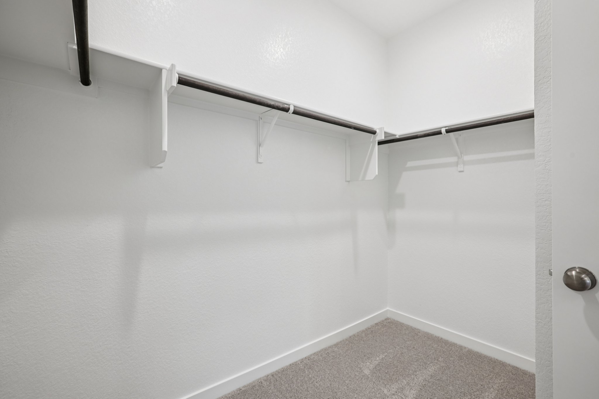 A white wall with a metal bar.