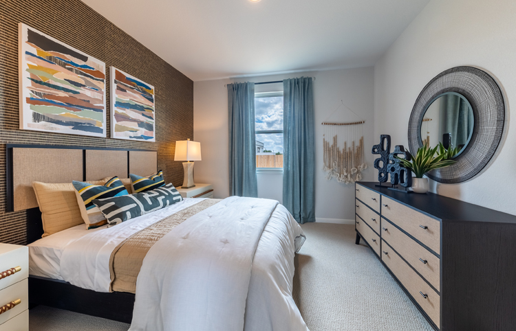 A bedroom with a bed and a mirror.