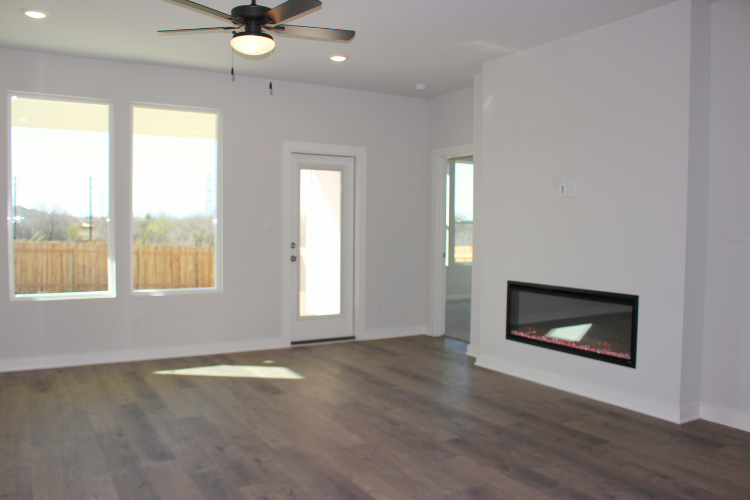 A room with a wood floor and a ceiling fan.
