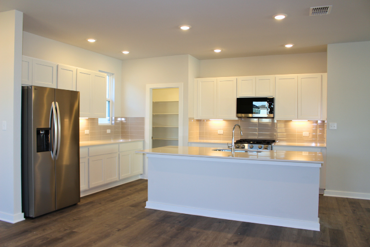 A kitchen with white cabinets.