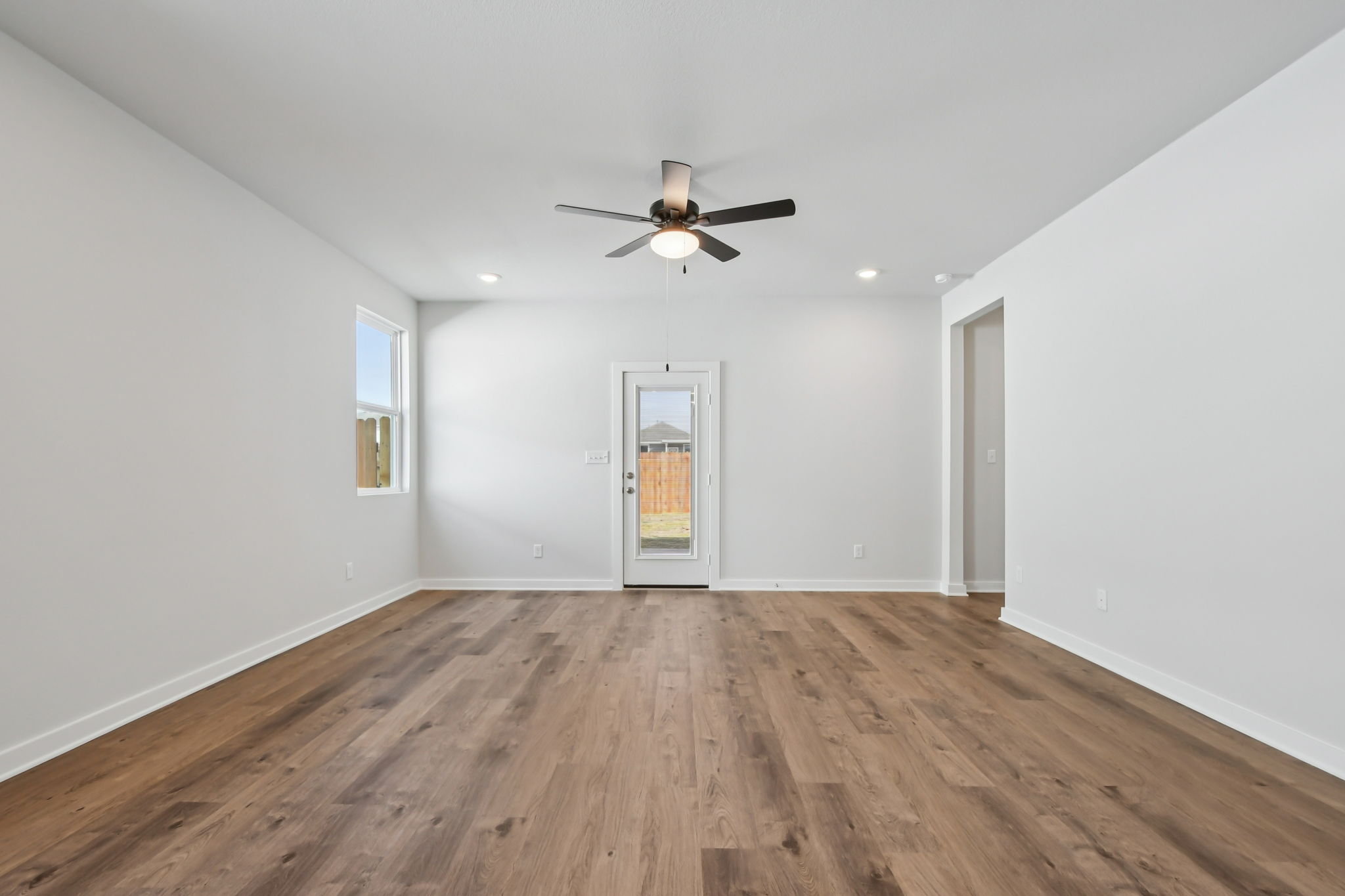 A room with a wood floor and a ceiling fan.