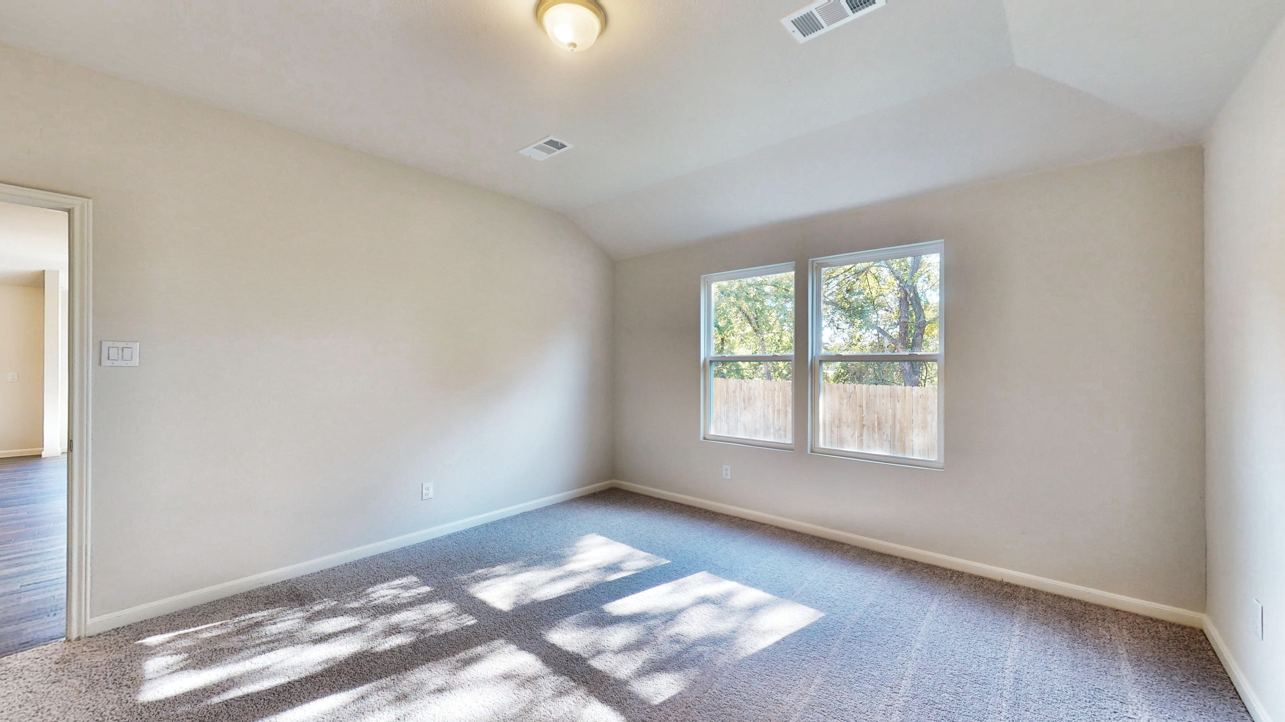 A room with a rug and windows.