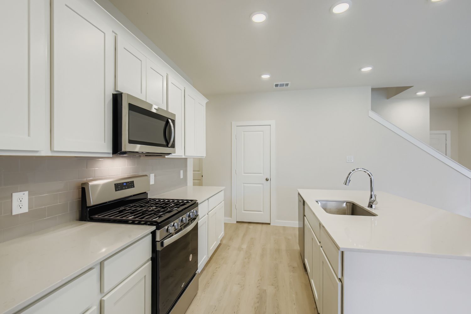 A kitchen with white cabinets.