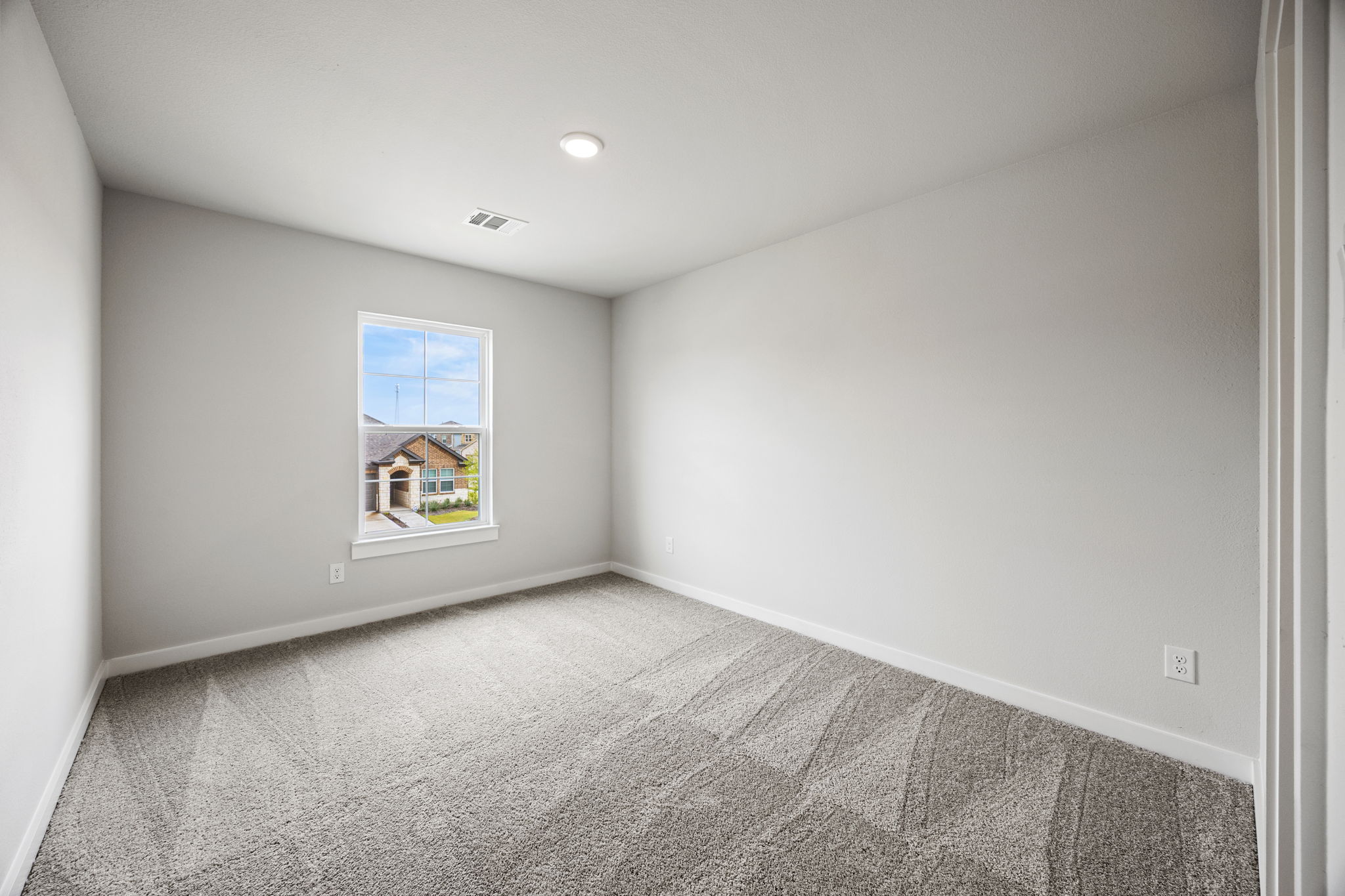 A room with a window and a carpet.