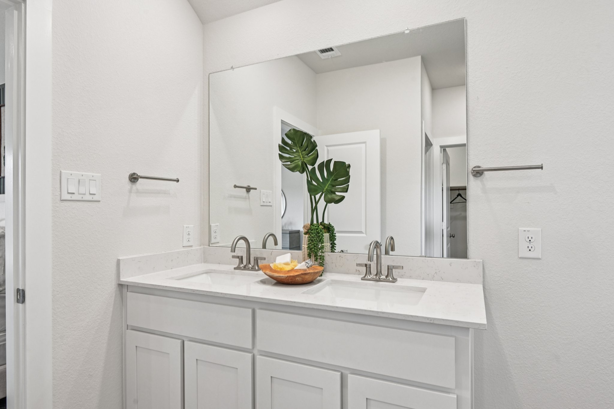 A bathroom with white cabinets.