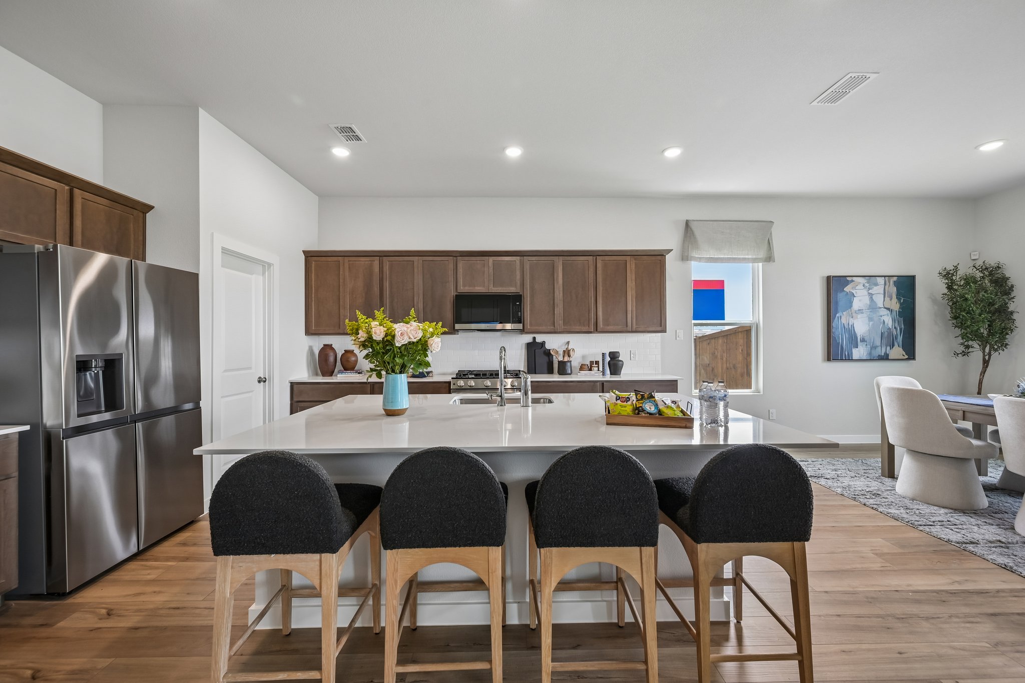 A kitchen with a dining table and chairs.