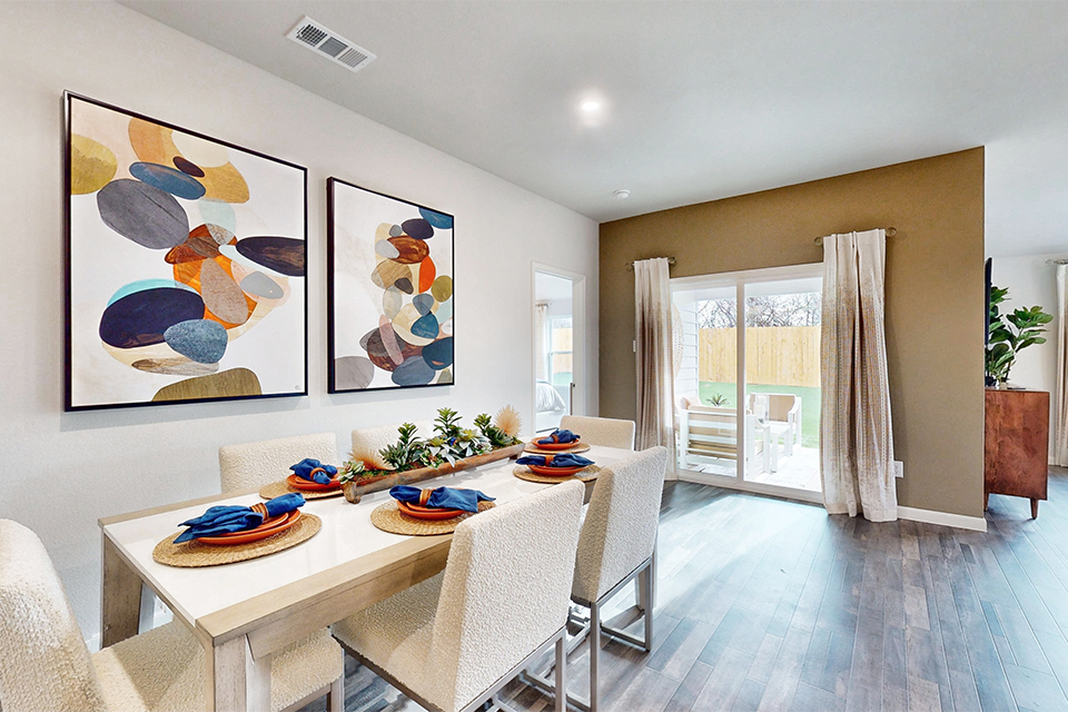 A dining room with a table and chairs.