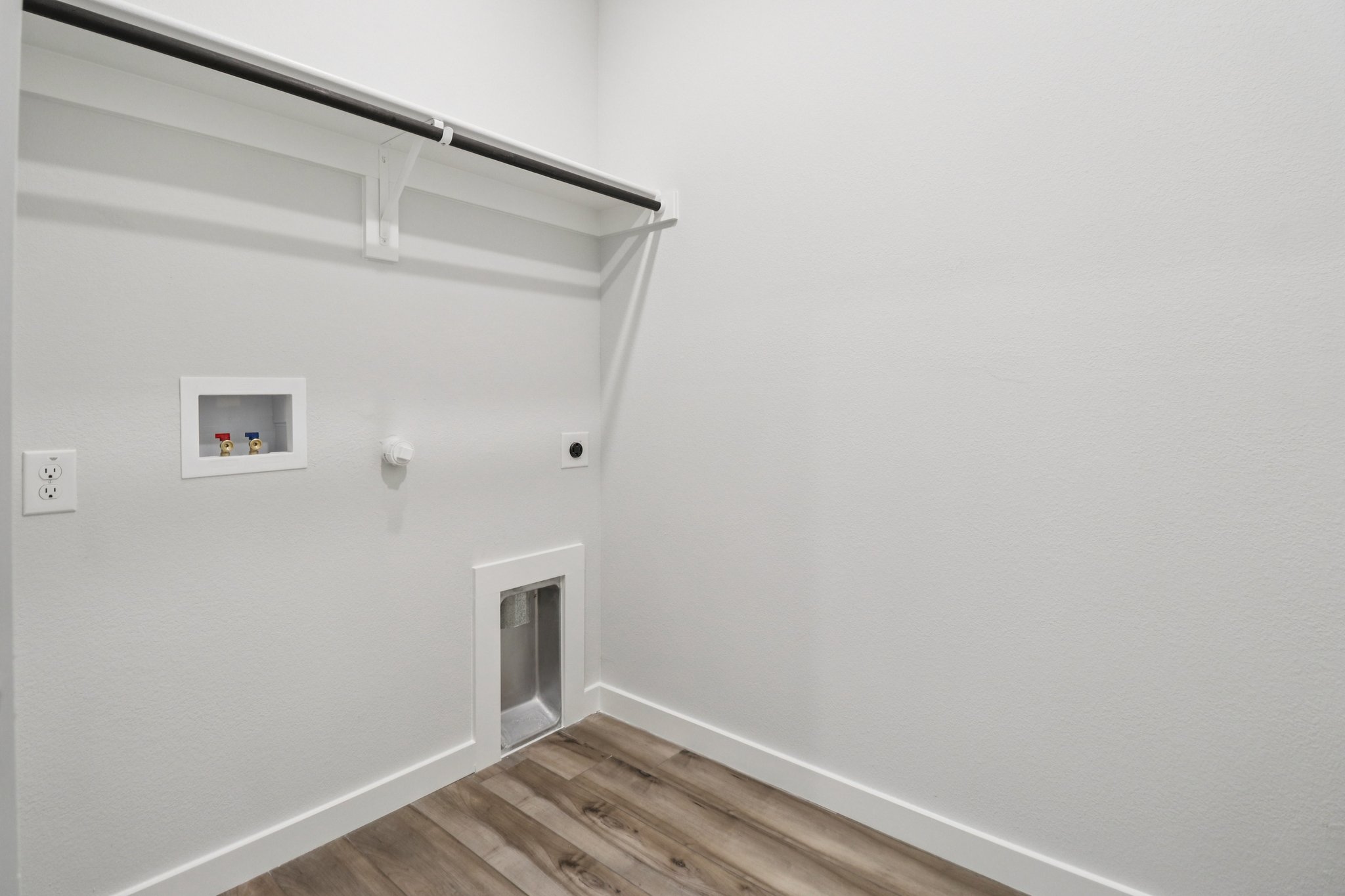 A white wall with a wood floor and a wood floor.